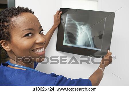 Doctor holding x-ray in hospital, portrait View Large Photo Image Picture - Doctor holding x-ray in hospital, portrait. Fotosearch