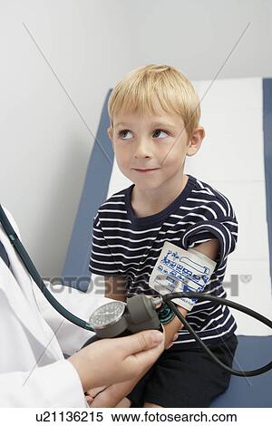 Doctor taking blood pressure of boy View Large Photo Image Stock Photography - Doctor taking blood pressure of boy. Fotosearch