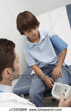 Stock Photo - Doctor taking boys blood pressure. Fotosearch