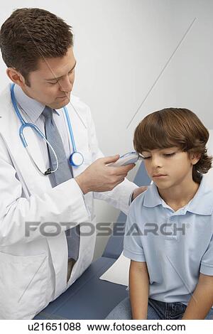 Stock Photo - Doctor taking boys temperature. Fotosearch