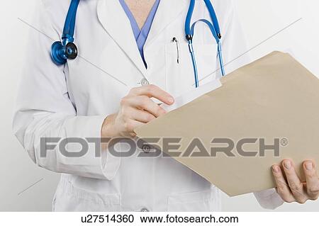 Stock Image - Doctor with medical file, mid section. Fotosearch
