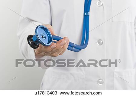 Stock Image - Doctor with stethoscope, mid section. Fotosearch