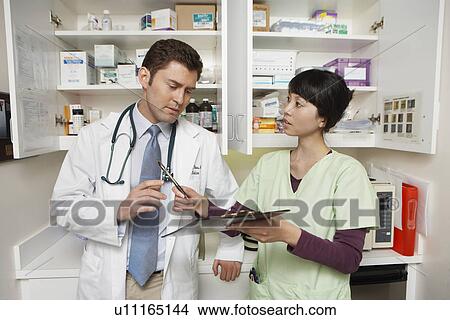 Doctor working with nurse in hospital View Large Photo Image Picture - Doctor working with nurse in hospital. Fotosearch