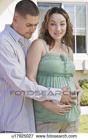 Expectant couple embracing outdoors View Large Photo Image Stock Photo - Expectant couple embracing outdoors. Fotosearch