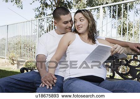 Expectant couple relaxing on bench View Large Photo Image Stock Image - Expectant couple relaxing on bench. Fotosearch