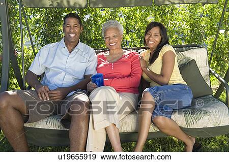 Stock Photo - Family on outdoor swinging chair. Fotosearch