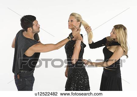 Stock Image - Fashion stylists attend to model. Fotosearch