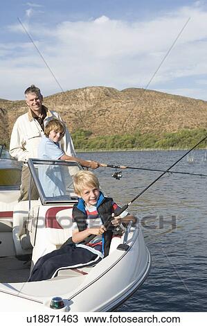 Stock Image - Father and sons fishing from a boat. Fotosearch