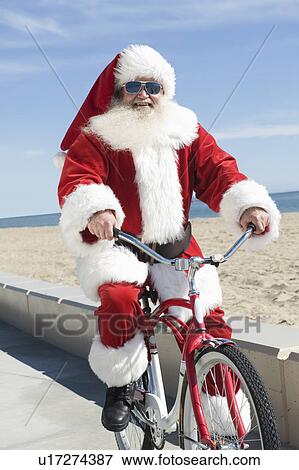 Stock Photo - Father Christmas cycles along promenade. Fotosearch