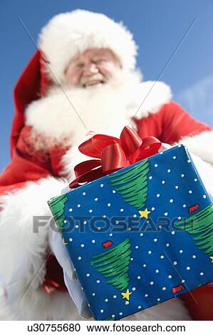 Father Christmas gives a present, low angle view View Large Photo Image Stock Image - Father Christmas gives a present, low angle view. Fotosearch