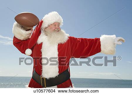 Picture - Father Christmas prepares to throw a rugby ball. Fotosearch