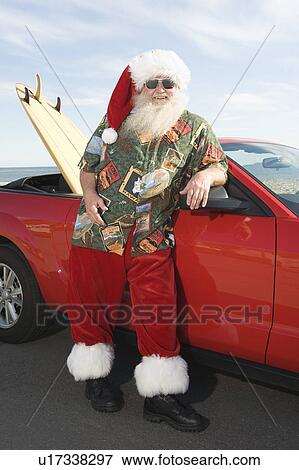 Father Christmas stands by red convertible with surfboard View Large Photo Image Stock Photo - Father Christmas stands by red convertible with surfboard. Fotosearch