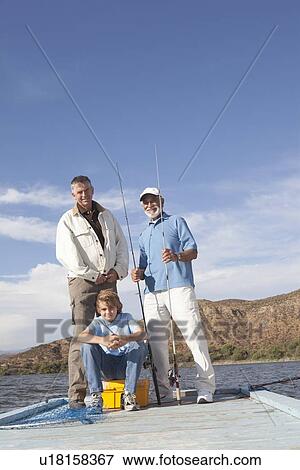 Father, son and grandson sit with fishing equipment on a pier View Large Photo Image Stock Photo - Father, son and grandson sit with fishing equipment on a pier. Fotosearch