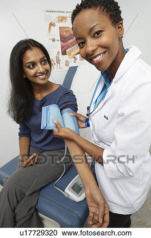 Female doctor checking patient's blood pressure View Large Photo Image Stock Image - Female doctor checking patient's blood pressure. Fotosearch