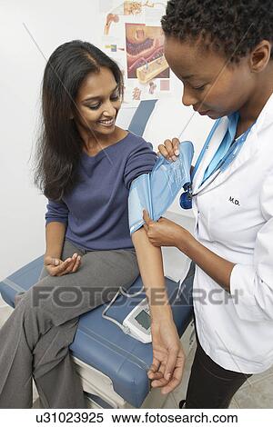 Female doctor checking patient's blood pressure View Large Photo Image Stock Photography - Female doctor checking patient's blood pressure. Fotosearch