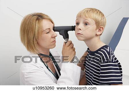 Stock Image - Female doctor examining boy. Fotosearch