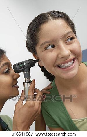 Female doctor examining girl View Large Photo Image Stock Photo - Female doctor examining girl. Fotosearch
