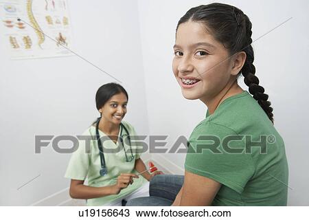 Female doctor examining girl with reflex hammer View Large Photo Image Stock Image - Female doctor examining girl with reflex hammer. Fotosearch