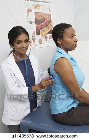 Female doctor examining patient View Large Photo Image Stock Photo - Female doctor examining patient. Fotosearch