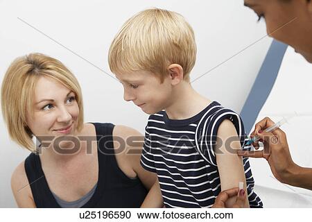 Stock Image - Female doctor giving boy injection. Fotosearch