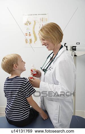 Stock Photo - Female doctor giving medicine to boy. Fotosearch