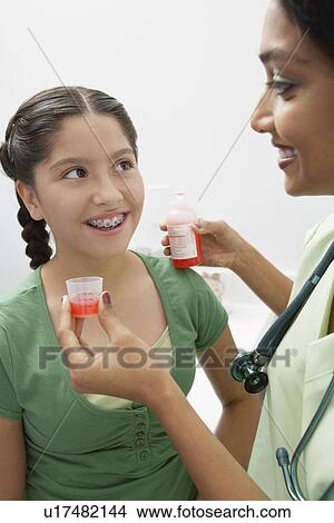 Picture - Female doctor giving medicine to girl. Fotosearch