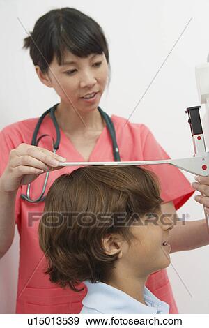 Female doctor measuring boy's height, close-up View Large Photo Image Stock Photo - Female doctor measuring boy's height, close-up. Fotosearch