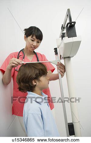 Female doctor measuring boy's height View Large Photo Image Stock Photography - Female doctor measuring boy's height. Fotosearch