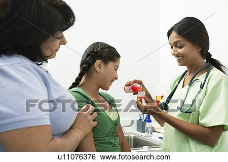 Female doctor pouring medicine for girl View Large Photo Image Stock Photograph - Female doctor pouring medicine for girl. Fotosearch