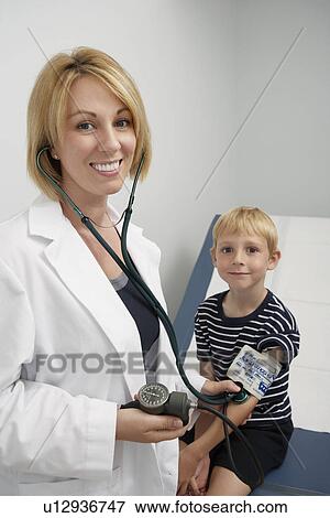 Stock Photo - Female doctor taking blood pressure of boy. Fotosearch