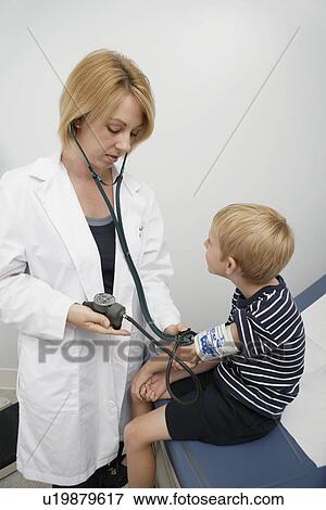 Stock Photo - Female doctor taking blood pressure of boy. Fotosearch