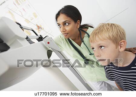 Female doctor weighting young patient View Large Photo Image Stock Photography - Female doctor weighting young patient. Fotosearch