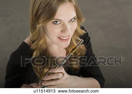 Stock Image - Female flautist smiles looking up at cameraq. Fotosearch