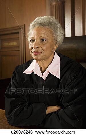 Stock Image - Female judge sitting in court, portrait. Fotosearch