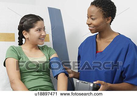 Female nurse taking girls blood pressure in hospital View Large Photo Image Stock Image - Female nurse taking girls blood pressure in hospital. Fotosearch