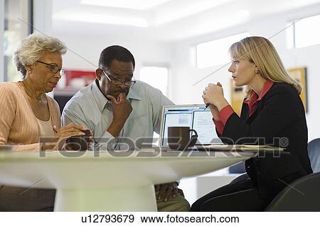 Stock Photo - Financial Advisor Assisting Senior Couple. Fotosearch
