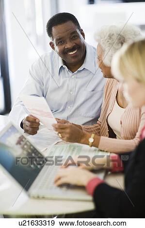 Stock Photo - Financial Advisor Assisting Senior Couple. Fotosearch