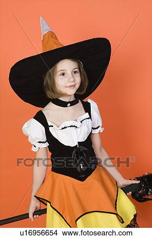Picture - Girl (7-9) wearing witch costume for Halloween, studio shot. Fotosearch