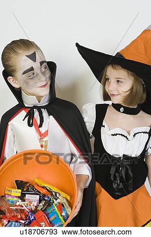 Girl and boy (7-9), wearing Halloween costumes, studio shot View Large Photo Image Stock Image - Girl and boy (7-9), wearing Halloween costumes, studio shot. Fotosearch