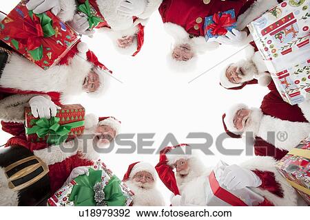 Group of men dressed as Santa Claus, looking down, low angle view View Large Photo Image Stock Image - Group of men dressed as Santa Claus, looking down, low angle view. Fotosearch