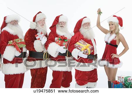 Group of men dressed as Santa Claus, Mrs Claus holding mistletoe View Large Photo Image Stock Image - Group of men dressed as Santa Claus, Mrs Claus holding mistletoe. Fotosearch