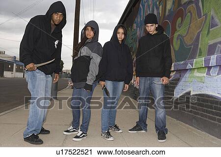 Stock Image - Group of young people posing with knives. Fotosearch