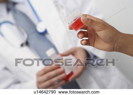 Hand holding medicine in liquid measure View Large Photo Image Stock Image - Hand holding medicine in liquid measure. Fotosearch
