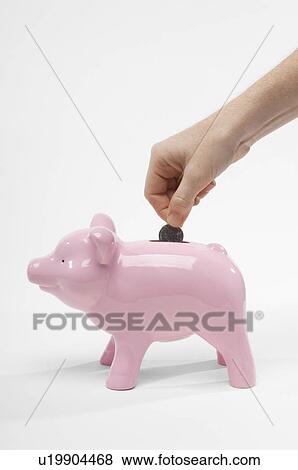 Stock Photo - Hand Putting Money in Piggy Bank. Fotosearch