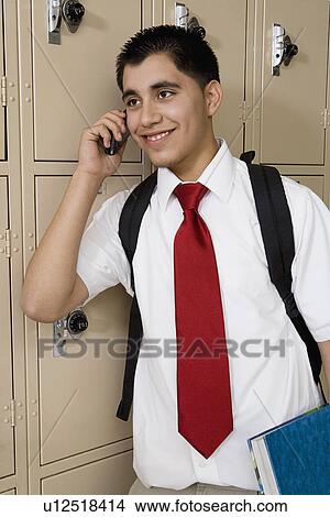 Picture - High School Boy Using Cell Phone by School Lockers. Fotosearch