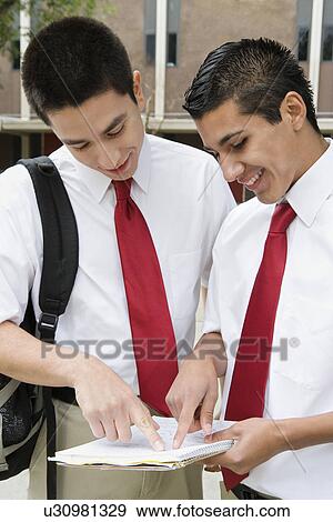 Stock Photo - High School Friends Looking at Paper. Fotosearch