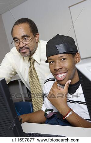 High School Teacher Helping Student View Large Photo Image Stock Photo - High School Teacher Helping Student. Fotosearch