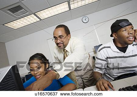 Stock Photo - High School Teacher Helping Student. Fotosearch