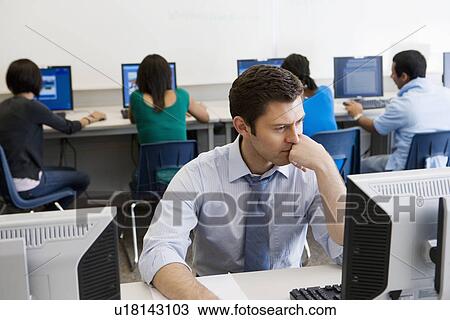 Stock Image - High School Teacher in Computer Lab. Fotosearch