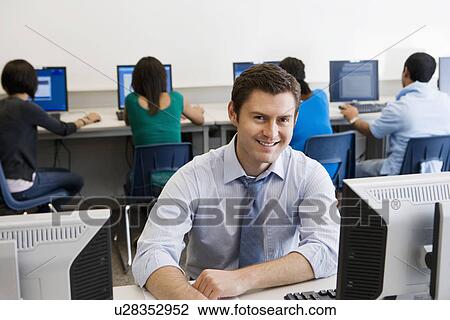 Stock Image - High School Teacher in Computer Lab. Fotosearch